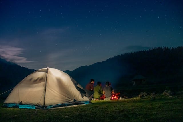 Night View of Camping With Men Gathered Around Bonfire
